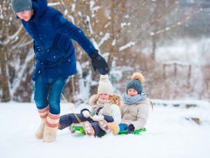 Activité luge en famille dans la neige