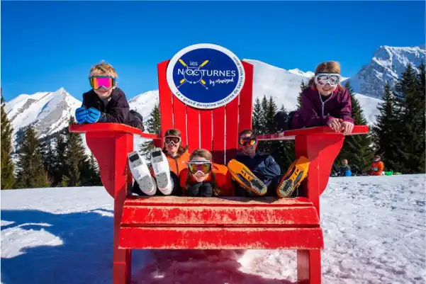 Enfants sur une chaise Canadienne à la station de ski de Manigod