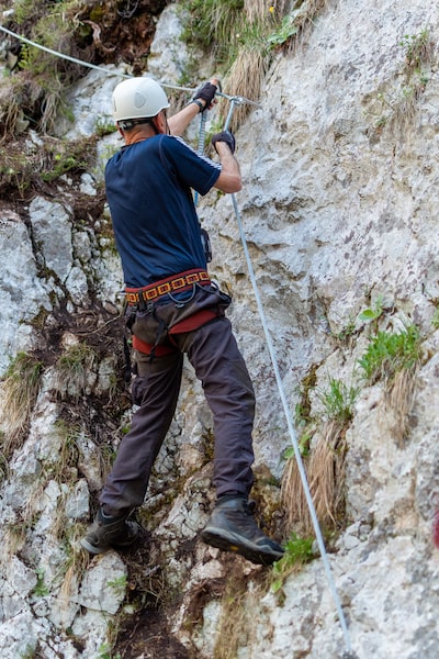 L'homme Escalade Une Haute Montagne De Danger Avec Une Corde