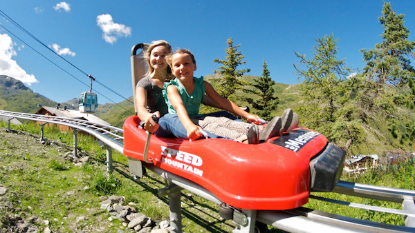 Femme avec enfant dans la luge sur rail des Menuires