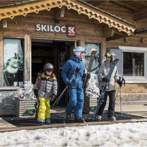 Famille qui sort d'un magasin de location de ski Skiset