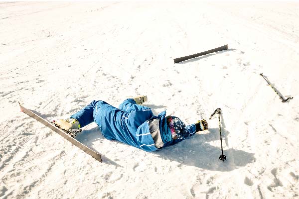 Skieur qui tombe par terre avec blessure à ski